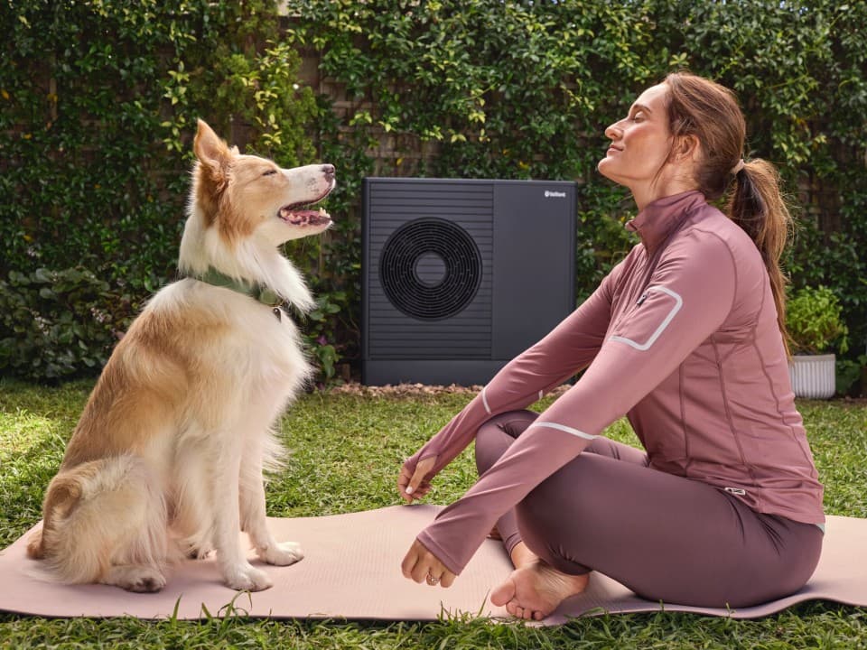 vrouw en hond voor een arotherm plus warmtepomp van vaillant