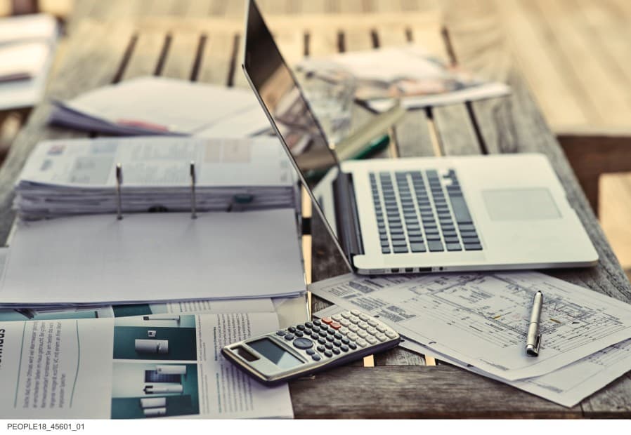 Laptop en papieren liggen op tafel